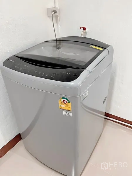 Townhouse for rent in Huai Khwang, Bangkok - Top-load washing machine installed in a utility corner with water supply.