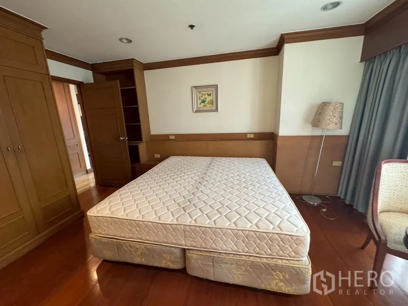 Condominium for rent in Watthana, Bangkok - Second bedroom with double bed, wardrobes, and wooden flooring.