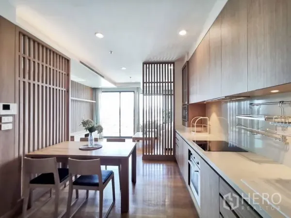 Condominium for rent in Sathon, Bangkok - Open-plan dining area beside a modern kitchenette with warm wood accents and sliding doors.