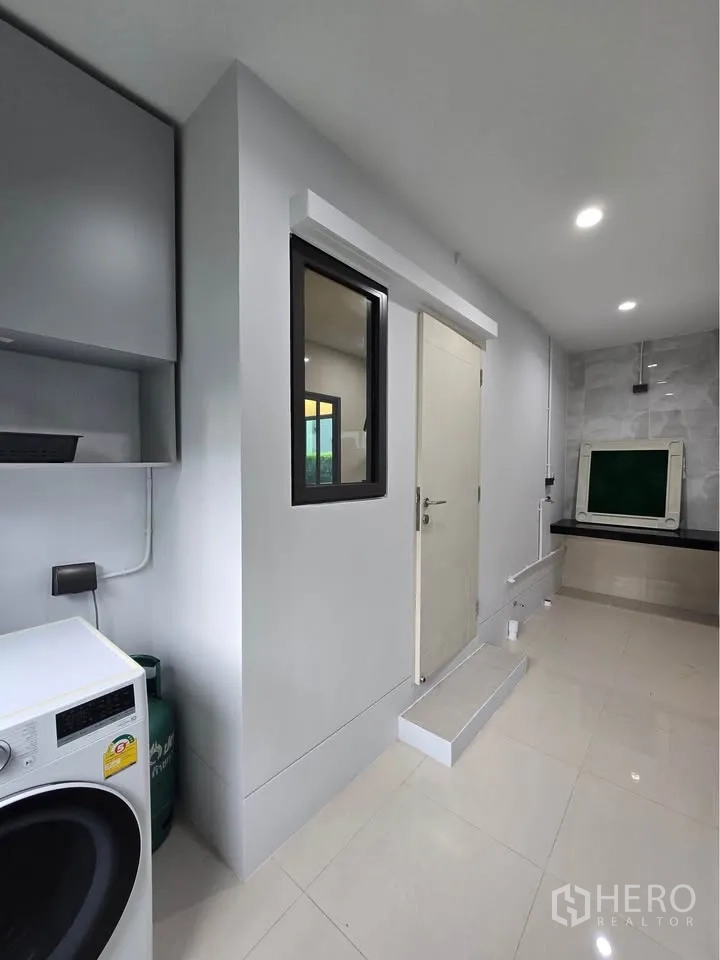 Detached House for rent in Bang Kapi, Bangkok - Utility room with washing machine, storage cabinets, and tiled floor.