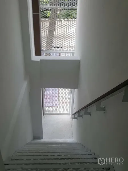 带办公室的家 出租在Khlong Toei, Bangkok - 白色楼梯间，木扶手，窗外为穿孔屏可眺望街景。