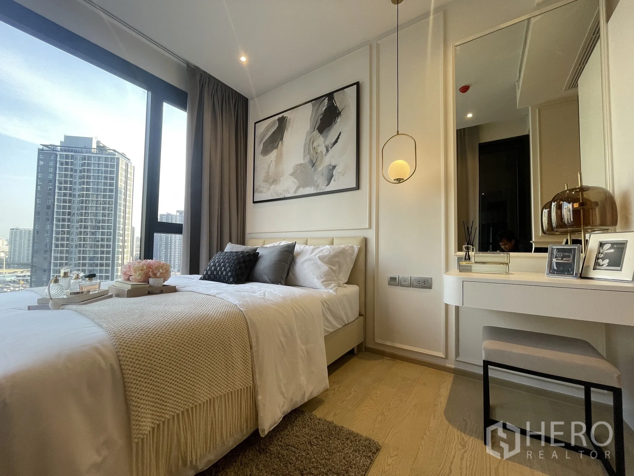 公寓 出租在Din Daeng, Bangkok - 卧室采光充足，大窗城市景观，柔软床品与带吊灯的梳妆台。