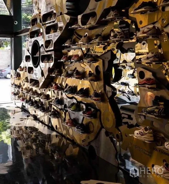 Shophouse for rent in Khlong Toei, Bangkok - Entrance area with glossy floor and geometric shelves filled with shoes.