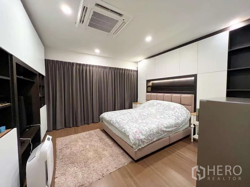独立式住宅 出售在Prawet, Bangkok - 主卧配特大床、内置收纳、天花机空调与遮光窗帘。