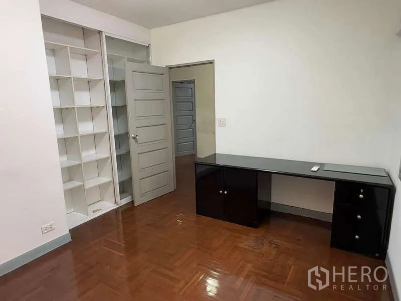 独立式住宅 出租在Bang Kapi, Bangkok - 书房带内置开放式书架和长黑色书桌。