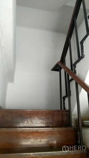 Retail Space for rent in Bang Rak, Bangkok - Narrow wooden staircase with black metal handrail inside a white stairwell.