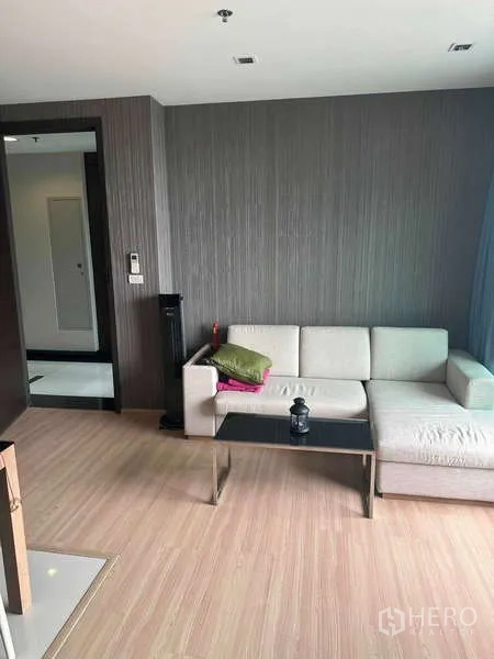Condominium for sale in Phaya Thai, Bangkok - Cozy lounge corner with sofa and coffee table near the entryway.