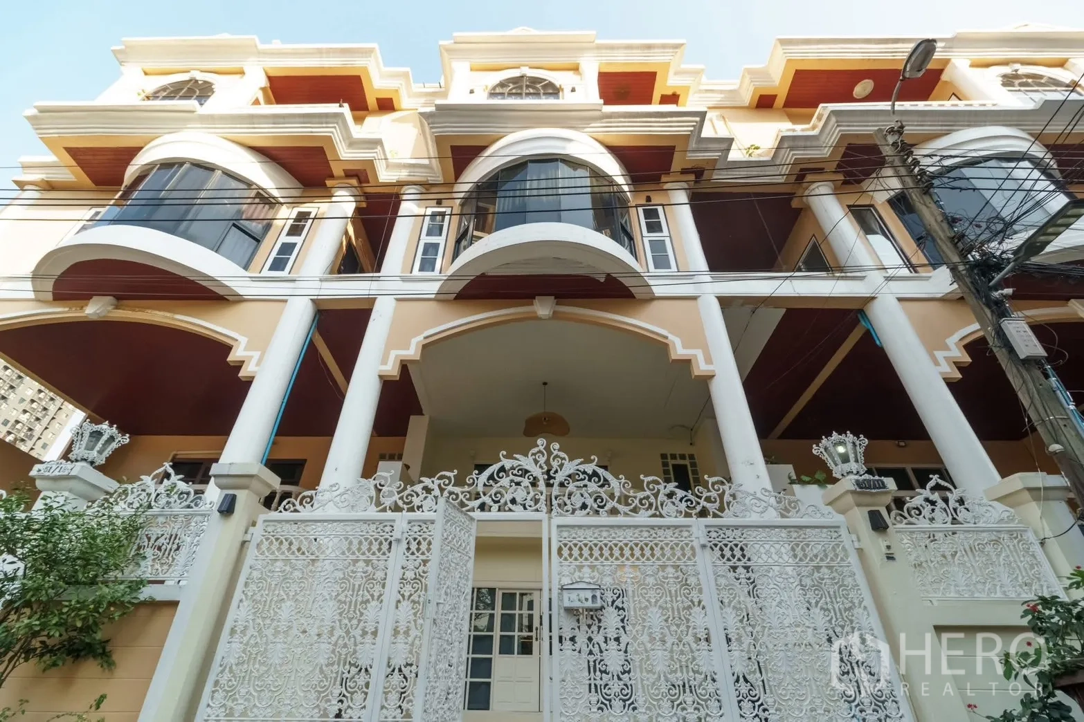 联排别墅 for rent in Watthana, Bangkok - 联排别墅外观，雕花大门、拱形立面与高柱。