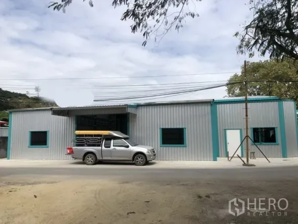货栈 出租在Lak Si, Bangkok - 临街单层仓库立面，带窗户与车道出入口。