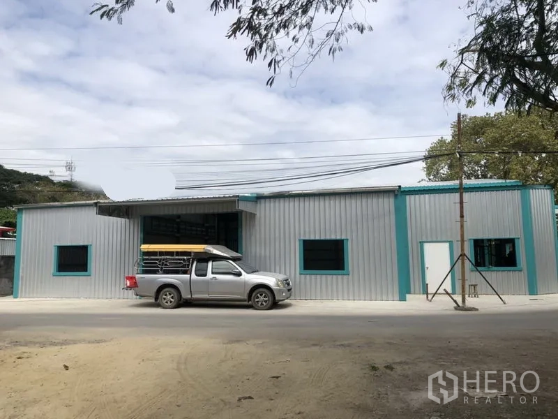 货栈 出租在Lak Si, Bangkok - 临街单层仓库立面，带窗户与车道出入口。