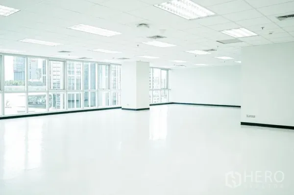办公空间 出租在Watthana, Bangkok - 明亮空旷楼层，荧光灯与转角玻璃窗。