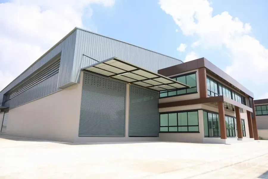 工厂 出租或出售在Bang Len, Nakhon Pathom - 邦伦全新厂房正立面，可见超大卷帘门、两层玻璃办公楼与带顶装卸雨棚。