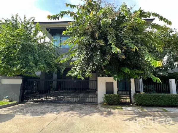 Detached House for rent or sale in Bang Kapi, Bangkok - Contemporary two-storey house facade with gated driveway and lush greenery.