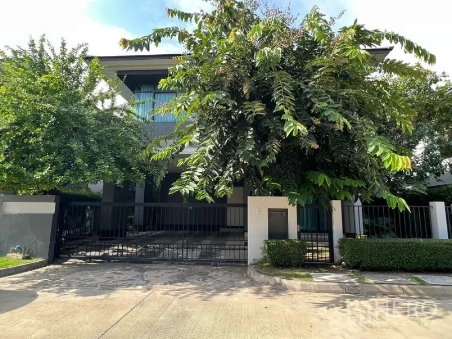 Detached House for rent or sale in Bang Kapi, Bangkok - Contemporary two-storey house facade with gated driveway and lush greenery.