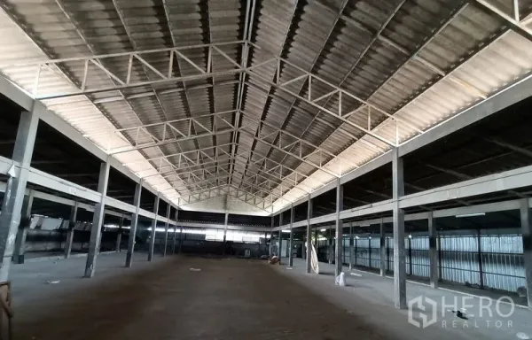 Warehouse for rent in Saphan Sung, Bangkok - Central aisle of empty warehouse under a metal truss roof with clear-span columns.