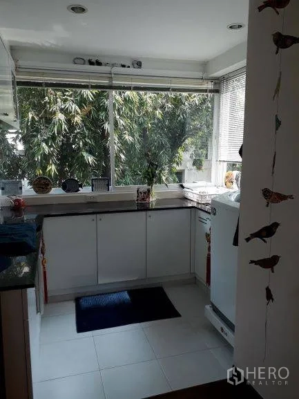 公寓 出租在Pathum Wan, Bangkok - 白色U型厨房，宽窗可见竹林绿景，台面空间充裕
