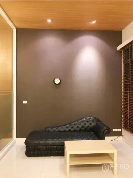 Townhouse for rent in Wang Thonglang, Bangkok - Cozy living room with accent wall, recessed lighting and lounge chaise.