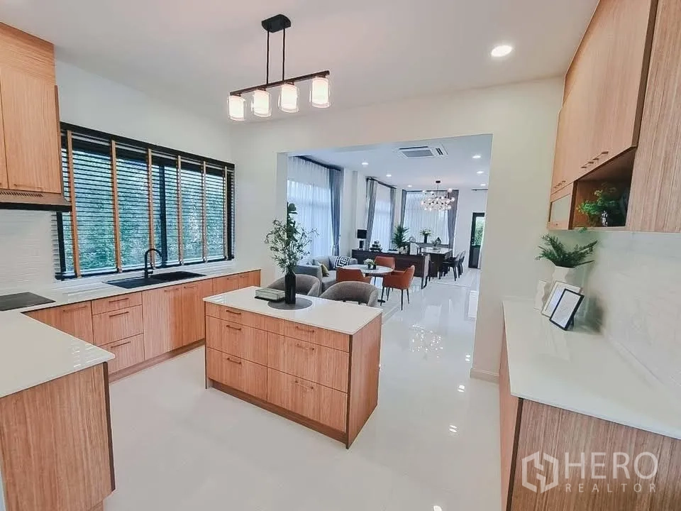 独栋房屋 for rent or sale in Bang Phli, Samut Prakan - 现代厨房带岛台与木质橱柜，可眺望餐客一体空间。