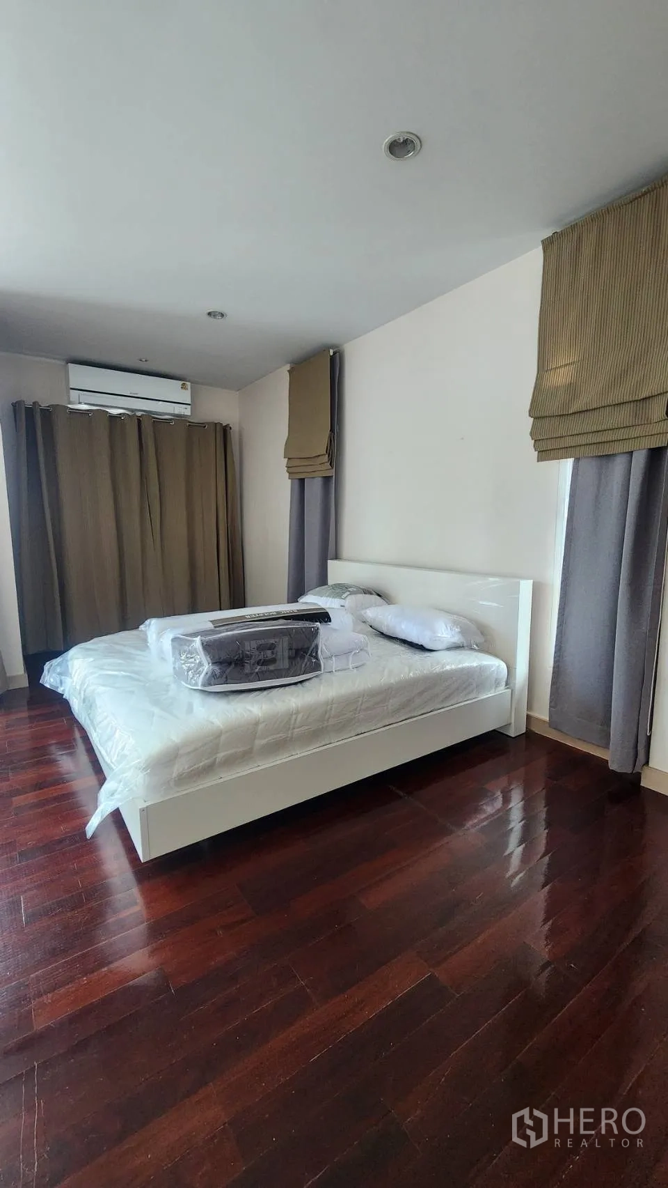 Detached House for rent in Watthana, Bangkok - Bedroom view showing bed, air-conditioner, and curtains.