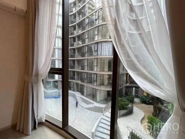 Condominium for rent in Khlong Toei, Bangkok - View from window with sheer curtains overlooking inner courtyard and pool steps