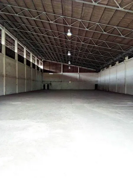 货栈 出租在Khlong Toei, Bangkok - 仓库内部宽敞，钢桁架高屋顶，混凝土地面与顶灯。