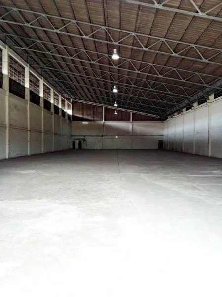 货栈 出租在Khlong Toei, Bangkok - 仓库内部宽敞，钢桁架高屋顶，混凝土地面与顶灯。