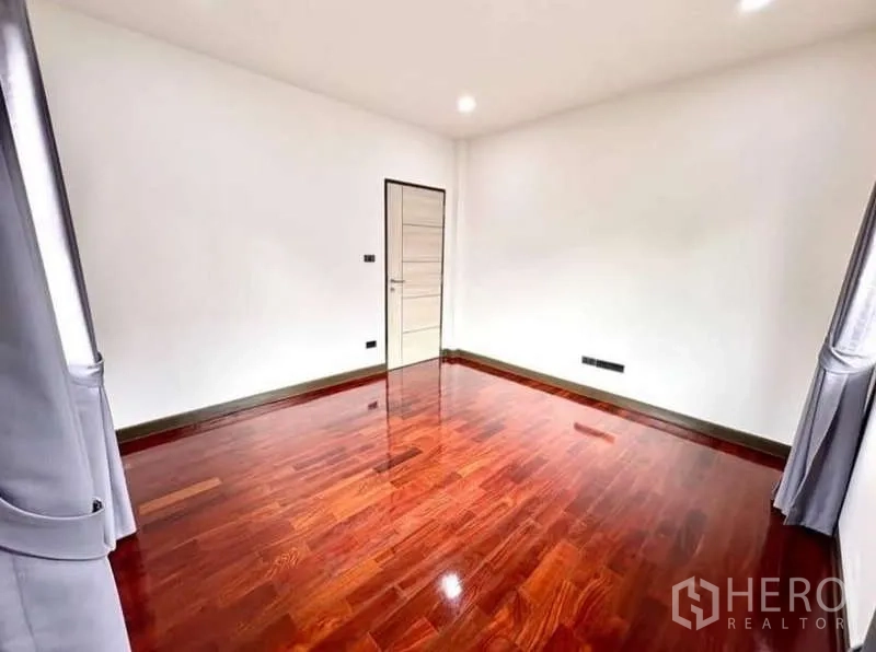บ้าน ให้เช่าในPhasi Charoen, Bangkok - ห้องนอนโล่งโปร่ง พื้นไม้เข้มและหน้าต่างพร้อมผ้าม่าน