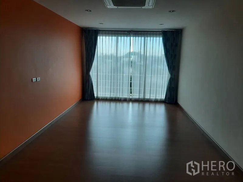 带办公室的家 出售在Phra Khanong, Bangkok - 空房间，橙色强调墙与落地窗帘，通向阳台。