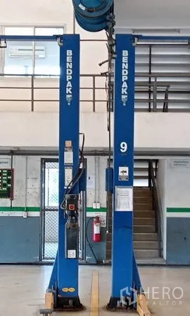 Warehouse for rent or sale in Lam Luk Ka, Pathum Thani - Interior workshop featuring twin two-post vehicle lifts and a mezzanine staircase.