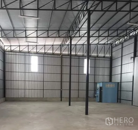 Warehouse for rent in Khan Na Yao, Bangkok - Open storage bay with steel columns, ventilated wall panels, and polished concrete floor.