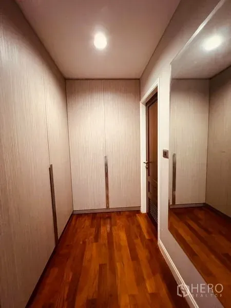 带办公室的家 出租在Khlong Toei, Bangkok - 步入式衣帽间走廊，整面嵌入式衣柜与大镜面，木地板。