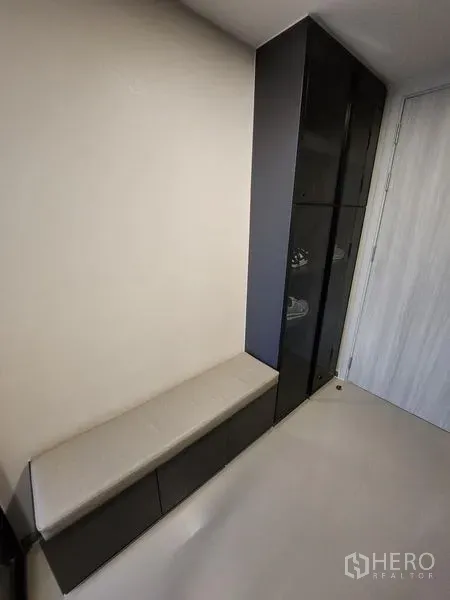 Condominium for rent - Entry corridor with a built-in bench and tall black storage cabinet.