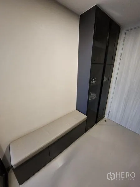 Condominium for rent - Entry corridor with a built-in bench and tall black storage cabinet.