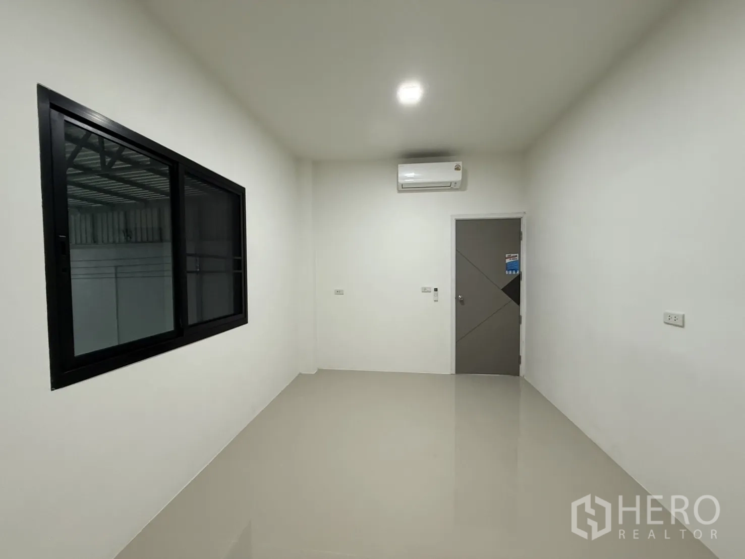 Warehouse for rent in Lam Luk Ka, Pathum Thani - Office with internal window to the warehouse and wall-mounted air conditioner.