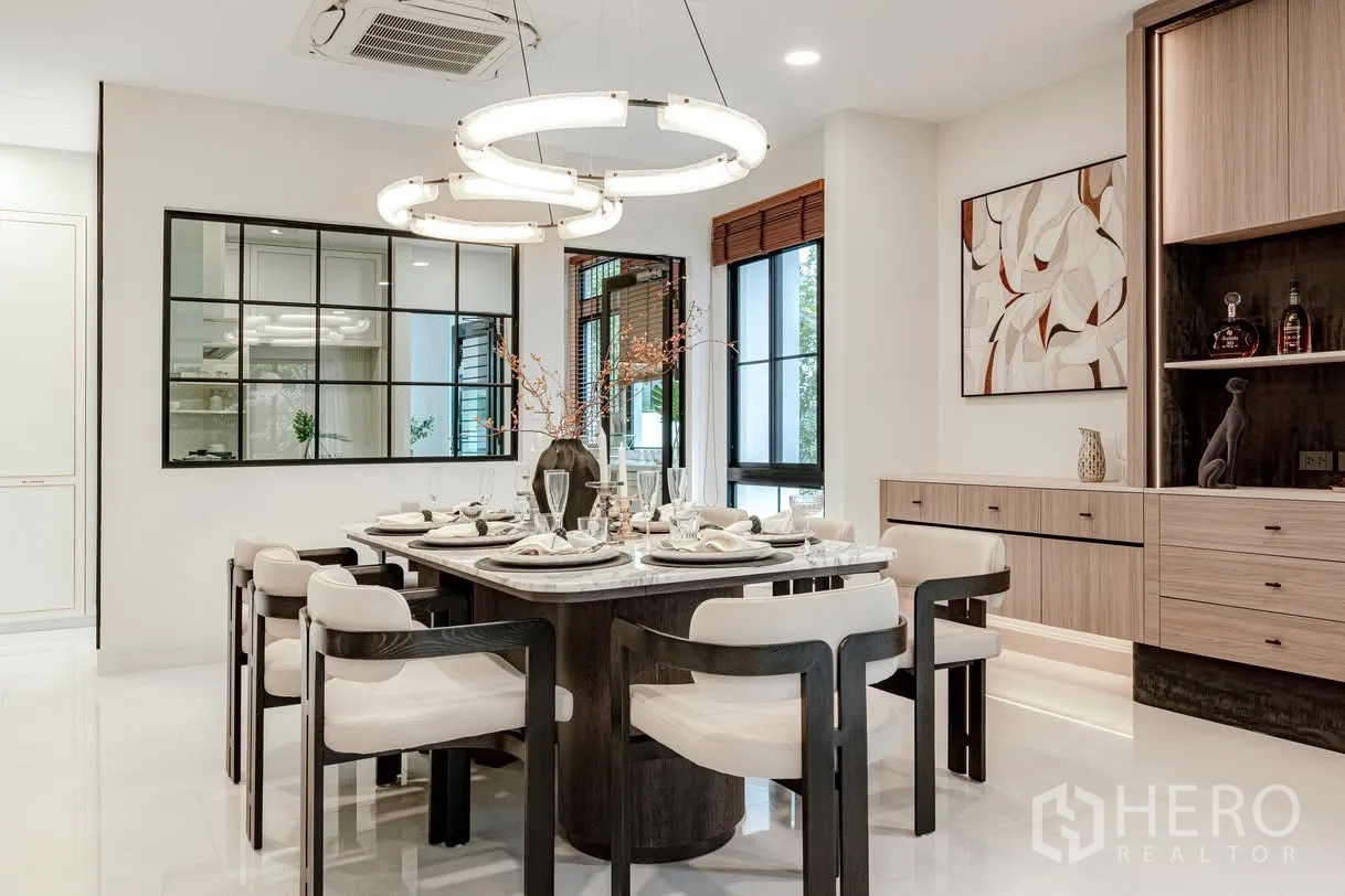 Detached House for rent in Saphan Sung, Bangkok - Stylish dining room with marble table, eight chairs, and ring pendant chandeliers.