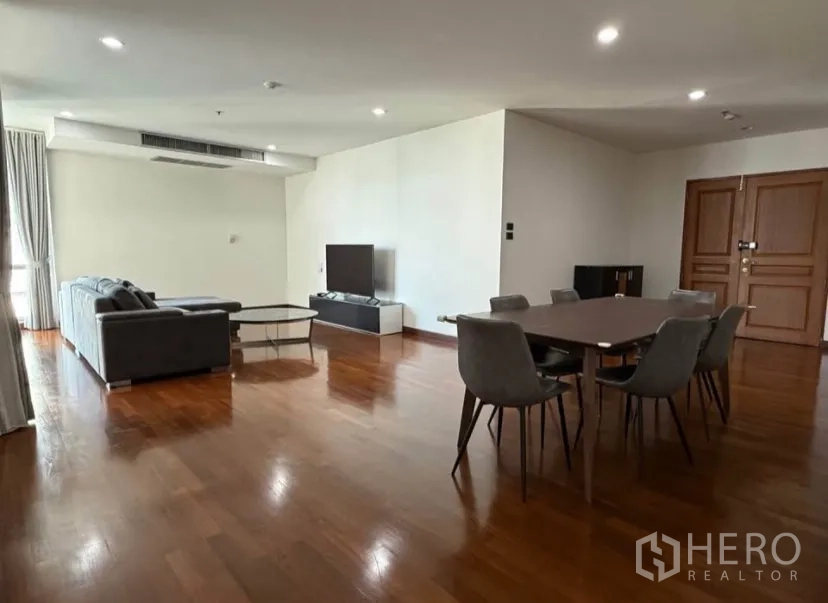 公寓 for rent in Pathum Wan, Bangkok - 宽敞的客餐厅，灰色沙发、电视与六人餐桌。