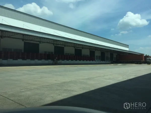 Warehouse for rent in Khlong Luang, Pathum Thani - Dock-high loading bays with wide canopy and container truck at a modern warehouse in Khlong Luang, Pathum Thani.