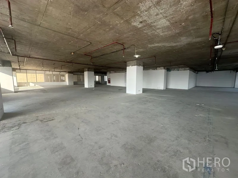 Office Space for rent in Watthana, Bangkok - Large shell office floor with exposed ceiling and fire sprinkler lines, open space with white columns and walls.