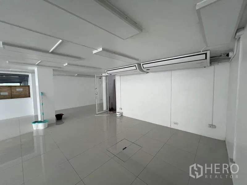 Retail Space for rent in Khlong Toei, Bangkok - Retail space showing twin ceiling cassette air conditioners and a glass entry door.