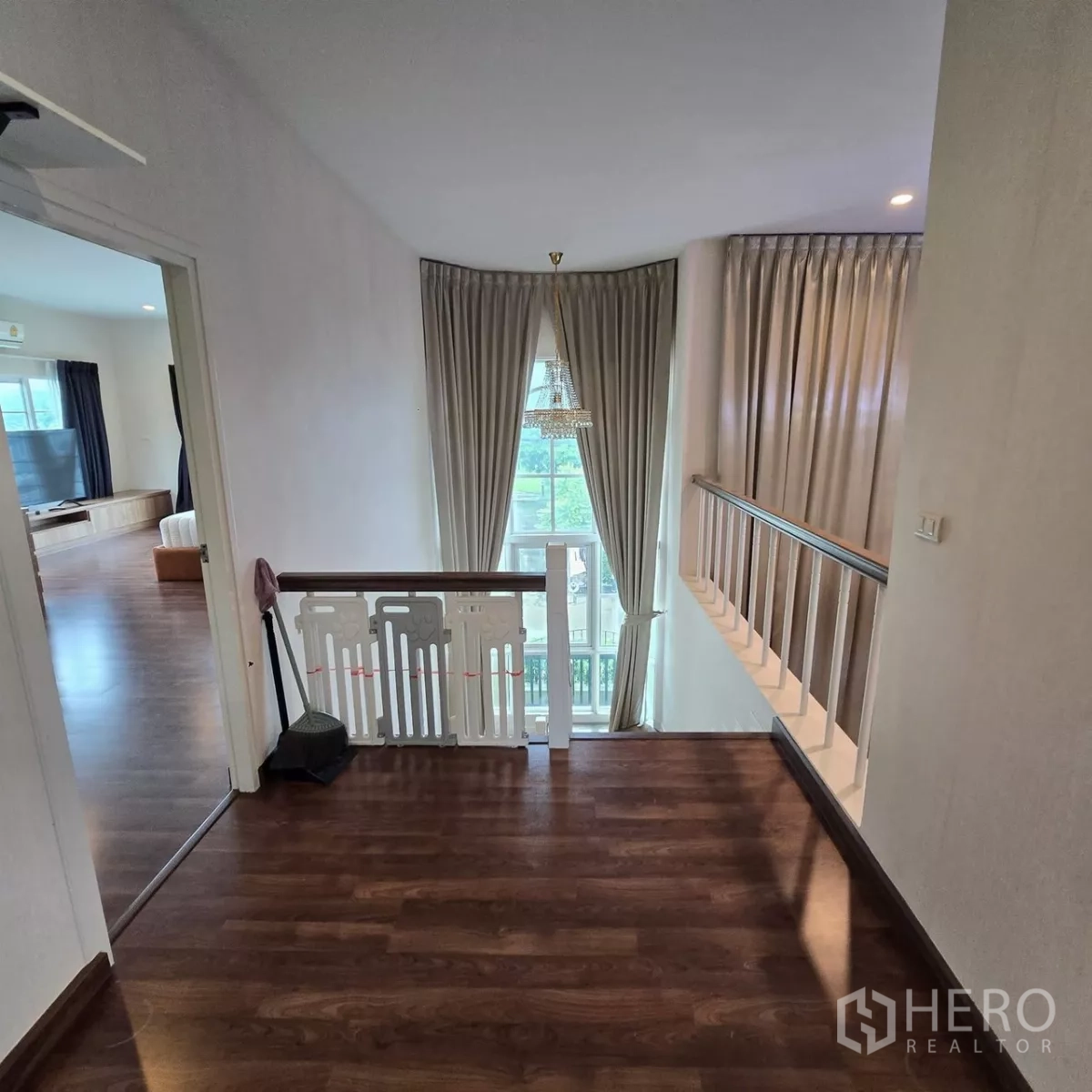 Detached House for rent in Mueang Pathum Thani, Pathum Thani - Upstairs landing showing chandelier and tall window over the living area.