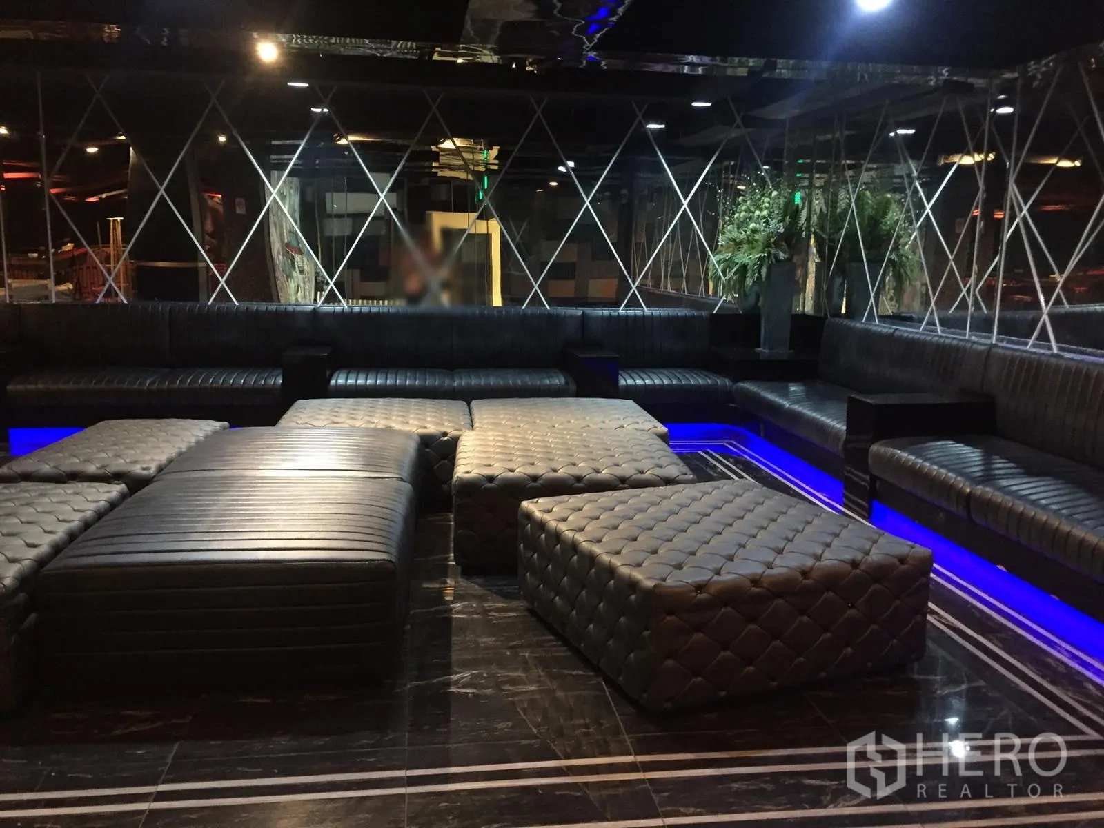 Retail Space for rent in Watthana, Bangkok - Dimly lit lounge with black leather banquettes, tufted ottomans and blue LED accents.