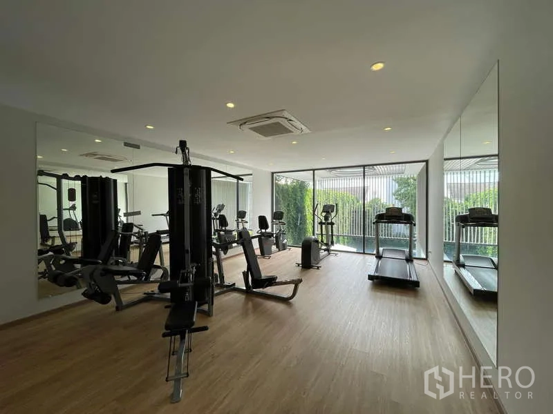 Home Office for rent in Don Mueang, Bangkok - Fitness room featuring treadmills, weight machines and mirrored walls.