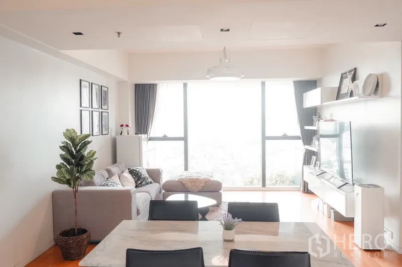 公寓 出租在Sathon, Bangkok - 从餐区望向客厅的大窗与转角沙发的视角