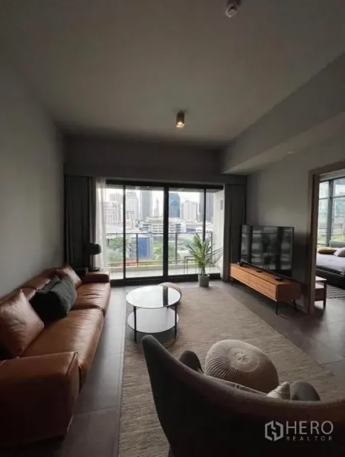 公寓 出租在Watthana, Bangkok - 现代客厅，皮质沙发、电视柜与可赏城市景观的阳台