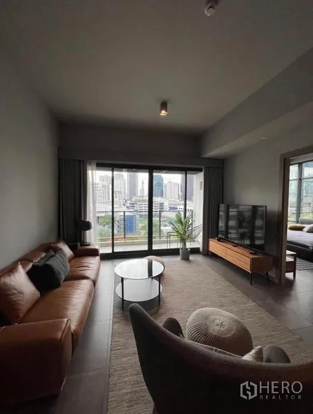 公寓 出租在Watthana, Bangkok - 现代客厅，皮质沙发、电视柜与可赏城市景观的阳台