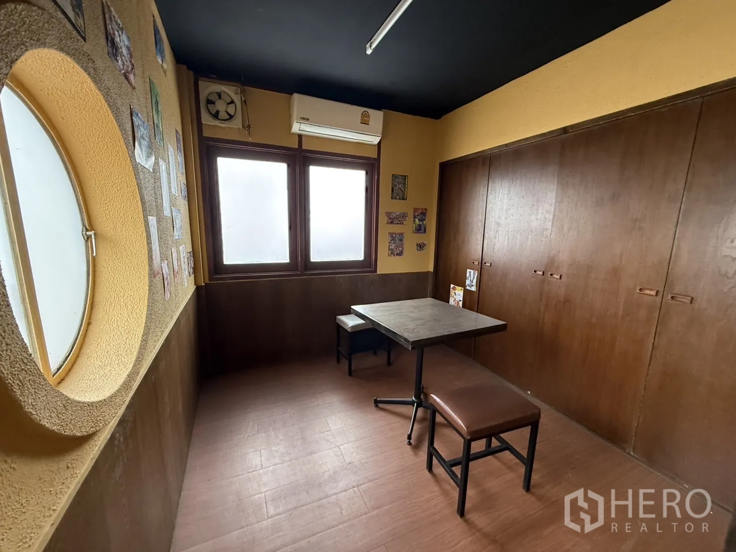 Detached House for rent in Watthana, Bangkok - Compact private room with round porthole window, table and bench.