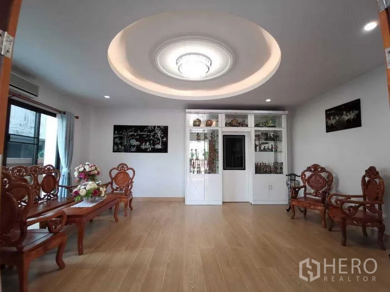 บ้าน ให้เช่าในPrawet, Bangkok - ห้องรับแขกสไตล์คลาสสิก ชุดเก้าอี้ไม้แกะสลัก เพดานหลุมพร้อมโคมระย้า และตู้โชว์สีขาว