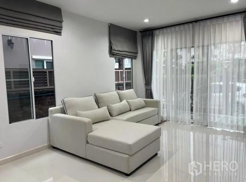 บ้าน ให้เช่าในSuan Luang, Bangkok - มุมห้องนั่งเล่น โซฟาสีอ่อนและประตูกระจกบานใหญ่