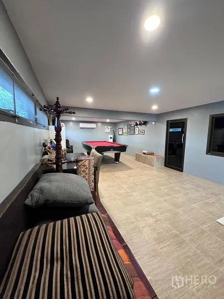 Detached House for sale in Bang Bua Thong, Nonthaburi - Spacious game room featuring a red felt pool table, seating and air conditioning.