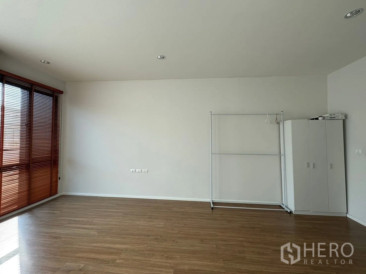 Townhouse for rent in Saphan Sung, Bangkok - Large empty room with wood flooring and window blinds.